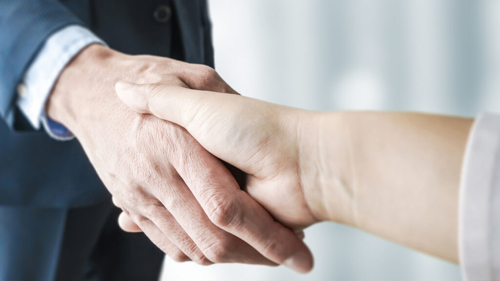 取り引き相手と握手する。
